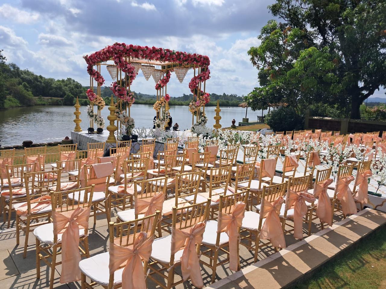 Serene riverside view of Mercure Devaaya Resort with blooming flowers and the Mandovi River